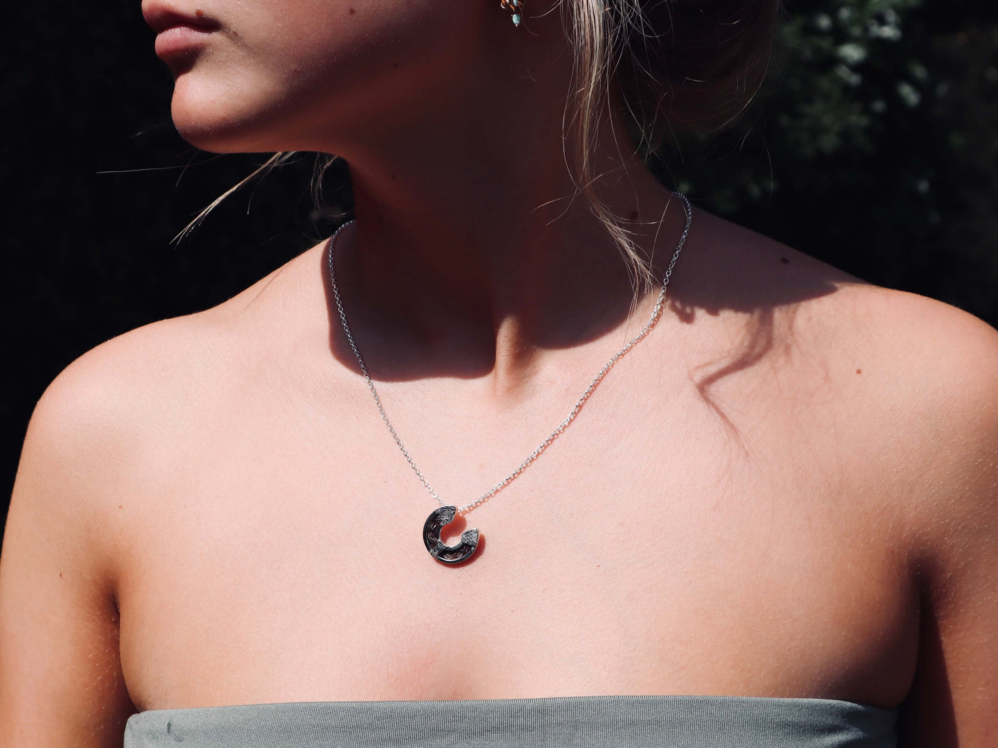 Model wearing a horse hair horseshoe necklace on a sterling silver chain.